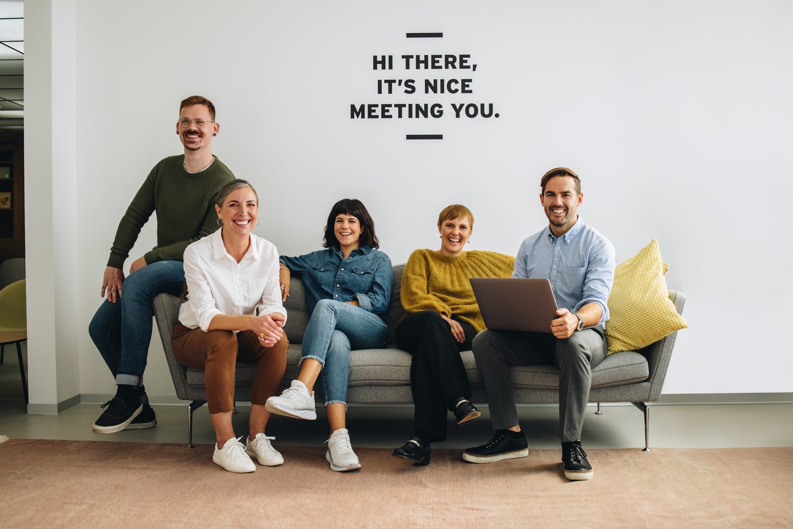 Équipe assise sur un canapé sous l'inscription « It's nice meeting you »